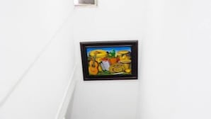 Una escalera blanca con barandilla metálica y un ventanal en la pared.