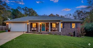 A single-story house with a front porch, a garage, and a well-maintained lawn.