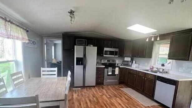 A compact kitchen with a wooden floor, a dining table with chairs, and a refrigerator. - Private Shawnee National Forest Retreat , Near Garden of the Gods (Elizabethtown)