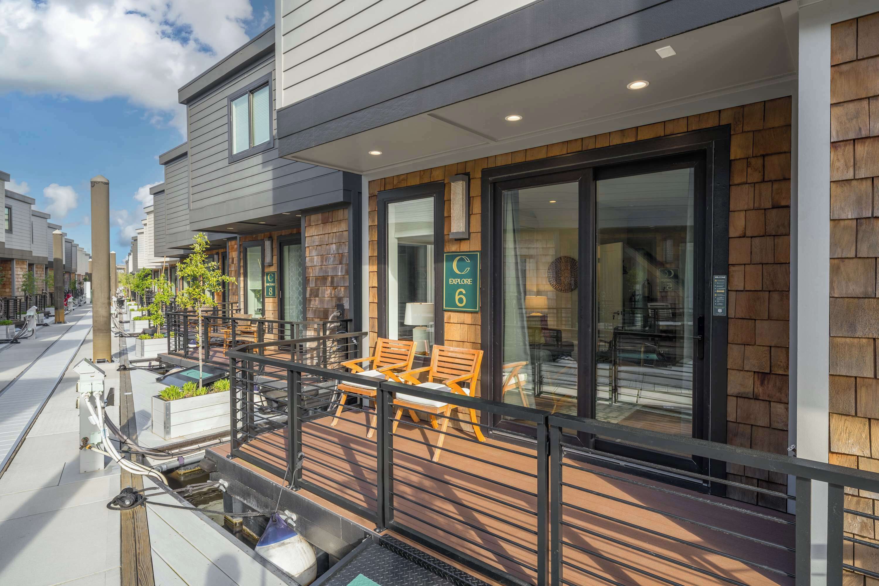 Un hotel moderno con una terrazza in legno, posti a sedere all'aperto e vista diretta sull'interno.