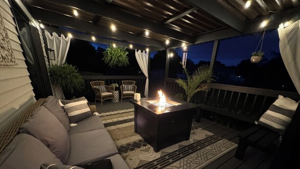 Una terraza exterior con un brasero, zona de estar y plantas en macetas.