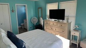 A bedroom with a bed, dresser, TV, and a fan. - Endless Summer Beach House
 (Cudjoe Key)