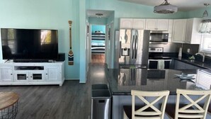 A modern kitchen with a central island, white cabinetry, and stainless steel appliances. - Endless Summer Beach House
 (Cudjoe Key)