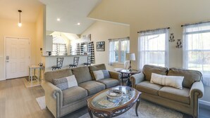 A spacious living room with two sofas, a coffee table, and a dining area with a table and chairs. - Wichita Townhome w/ Patio: 9 Mi to Downtown! (Wichita)