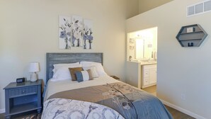 A bedroom with a bed, nightstand, and wall art. - Wichita Townhome w/ Patio: 9 Mi to Downtown! (Wichita)