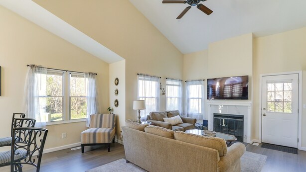 A spacious living room with a large sofa, a fireplace, and a television. - Wichita Townhome w/ Patio: 9 Mi to Downtown! (Wichita)