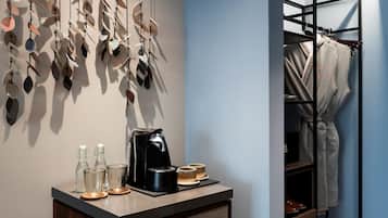 A modern bathroom with a coffee machine, glasses, and a towel rack.