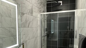 A modern bathroom with a glass-enclosed shower, a white sink, and a toilet. - Granada Apartments Holmfield Rd flat 3 1st floor front (Blackpool)