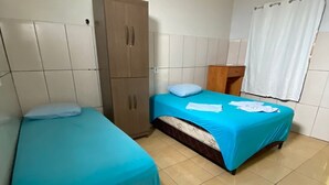 A room with two beds, a wardrobe, and a window with curtains. - Hotel ferraz (Tucumã)