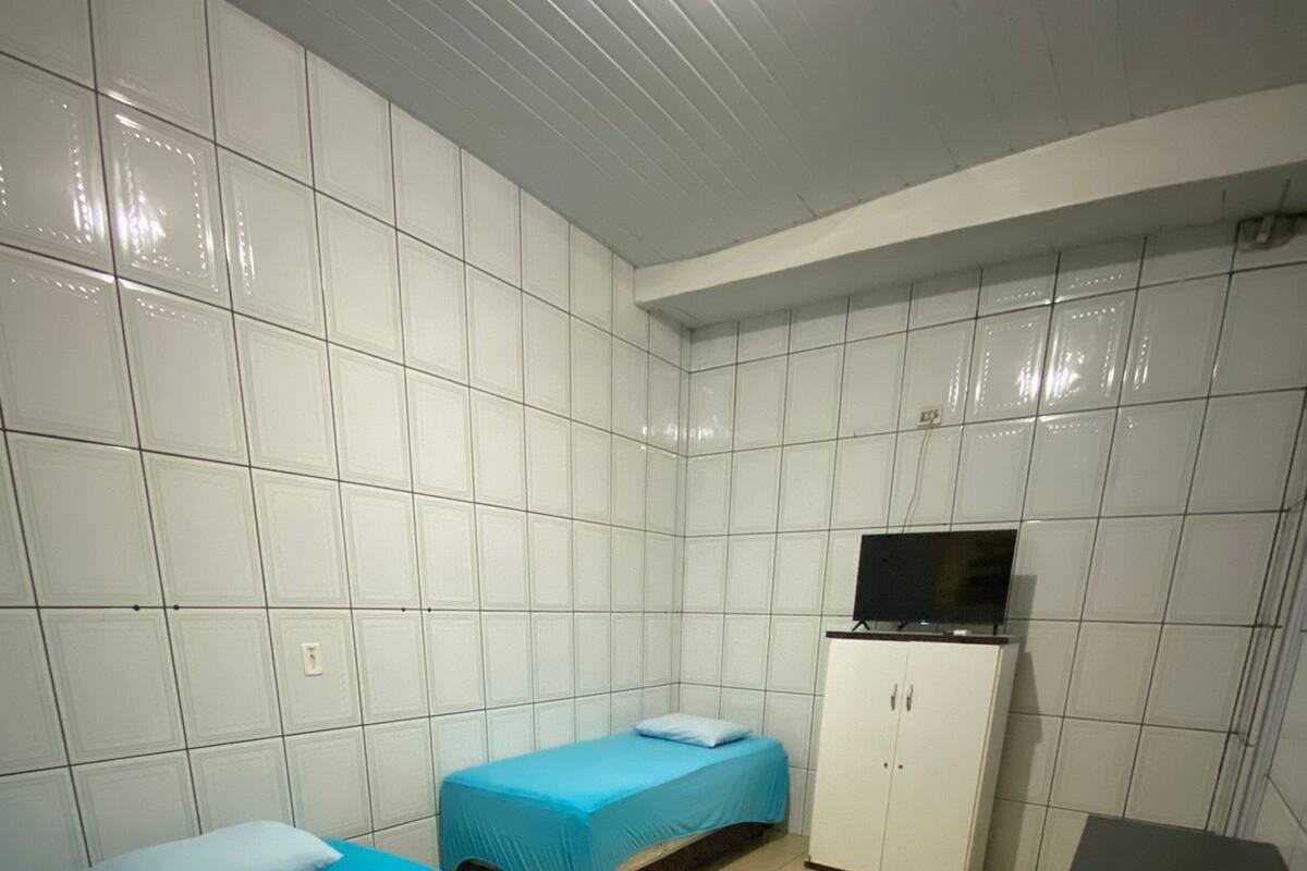 A room with two beds, a TV, and a cabinet.