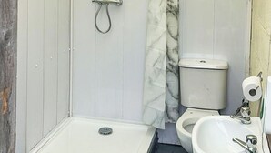 A bathroom with a shower, toilet, and sink.