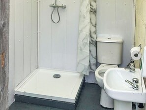 Ein Badezimmer mit Dusche, Toilette und Waschbecken.