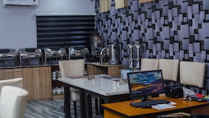 Een moderne keuken met roestvrijstalen apparatuur, een marmeren aanrecht en een zithoek met een computerbureau en stoelen.
