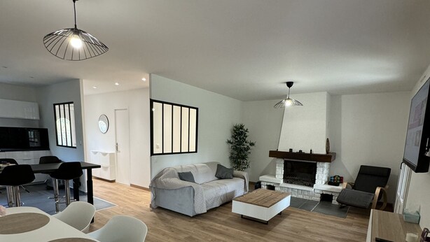 Una sala moderna con comedor, un sofá, una mesa de centro y una chimenea.