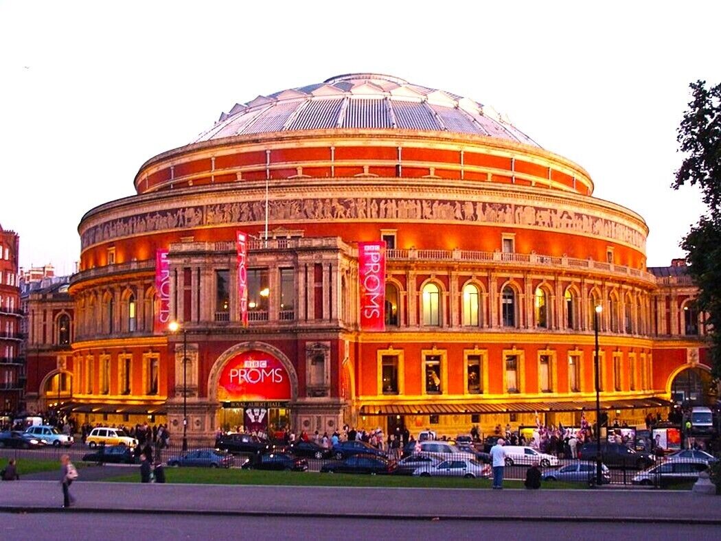 A historic building with a large dome and classical architecture, featuring prominent signage for a hotel and a restaurant.