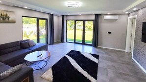 A modern living room with a sofa, coffee table, and a black and white rug.
