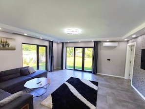A modern living room with a sofa, coffee table, and a black and white rug.