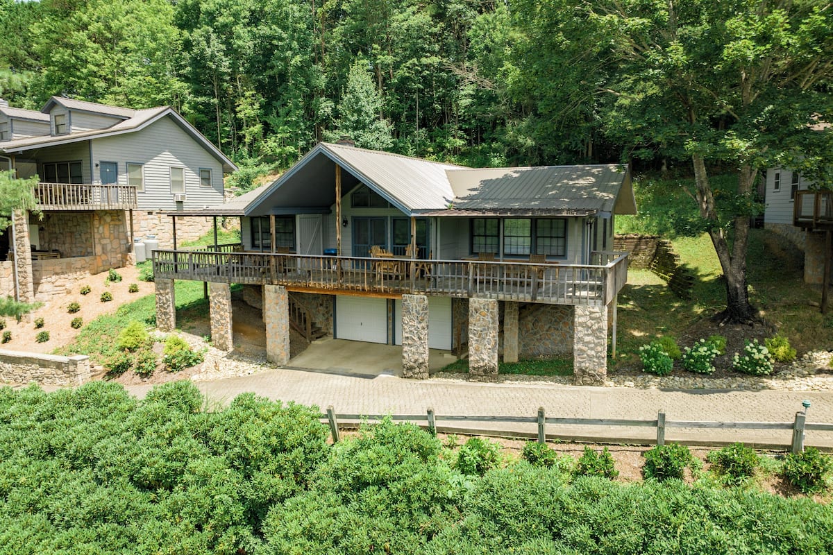 A two-story house with a stone foundation, a balcony, and a garage.