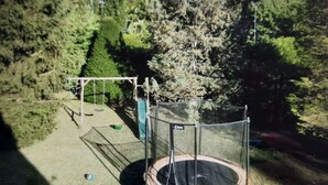 A trampoline in a fenced area with trees in the background. - Maison Lumineuse et Spacieuse en Forêt (Buthiers)