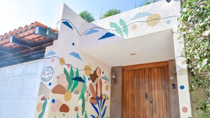 Ein Haus mit Wandgemälde, einer Holztür und einer Garage.