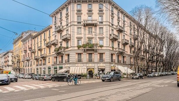 Un edificio de varios pisos con estilo arquitectónico clásico, que presenta una entrada central con dosel.
