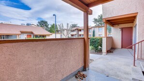 A covered outdoor area with a concrete floor, a wooden pergola, and a building with a red door. - WFH-Friendly Las Vegas Condo: 2 Mi to Strip! (Las Vegas)