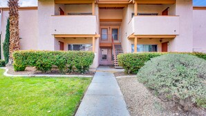 A two-story building with a central entrance, balconies on each floor, and a small staircase leading to the entrance. - WFH-Friendly Las Vegas Condo: 2 Mi to Strip! (Las Vegas)