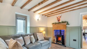 A cozy living room with a grey sofa, a fireplace, and exposed wooden beams. - 2 bedroom accommodation in Bonsal, near Matlock (Bonsal, near Matlock)