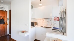 A modern kitchen with white cabinets, a toaster, a sink, and a decorative backsplash. - Stunning apartment in Bordighera (Bordighera)