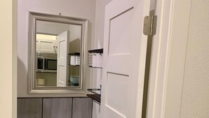 Une petite salle de bain avec des toilettes, un lavabo et un miroir au-dessus du lavabo.