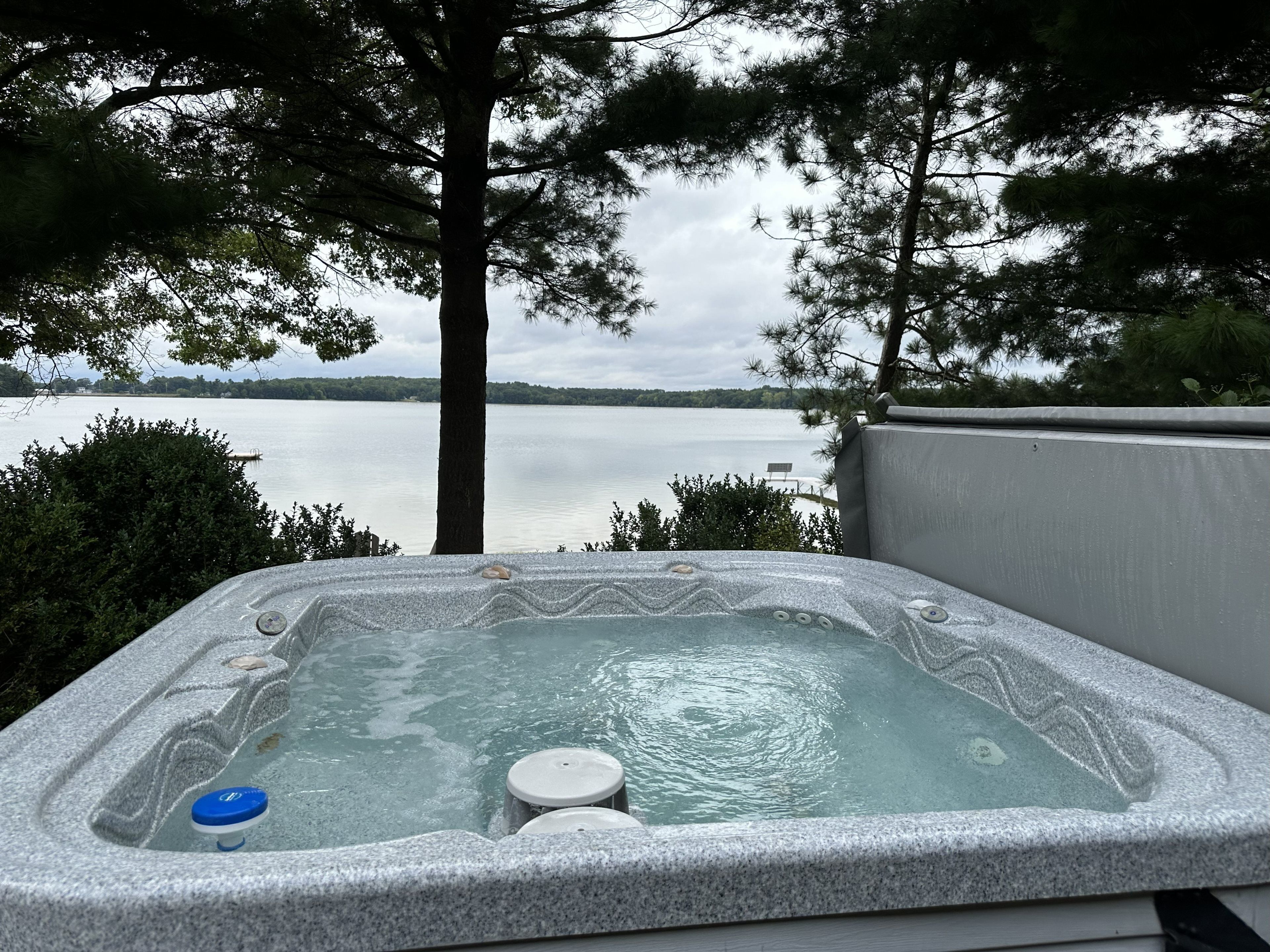 Un jacuzzi con vista a un lago y árboles.
