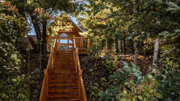 A wooden staircase leading to a cabin surrounded by trees. - Free nite w/wknd offseason;logcabin lake hottub kayak paddleboard pier fireplace (Wild Rose)