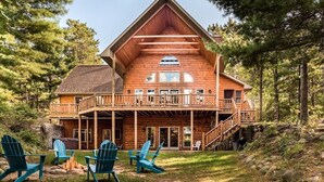 A large wooden lodge with a balcony, outdoor seating, and a fire pit. - Free nite w/wknd offseason;logcabin lake hottub kayak paddleboard pier fireplace (Wild Rose)