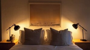 A neatly made bed with two bedside lamps, a vase, and a framed picture on the wall. - Furnished Bachelor in Hollywood (Los Angeles)