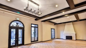 A spacious room with a fireplace, large windows, and an exit sign. - Furnished Bachelor in Hollywood (Los Angeles)