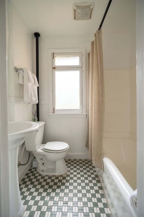 A small, clean bathroom with a toilet, sink, and window.