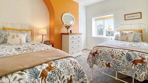 Een slaapkamer met twee bedden, een kaptafel, een spiegel en een raam met uitzicht.