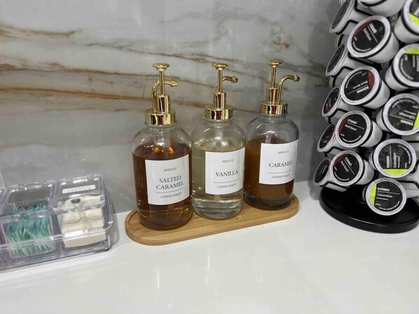 Three bottles of coffee syrup on a wooden tray.