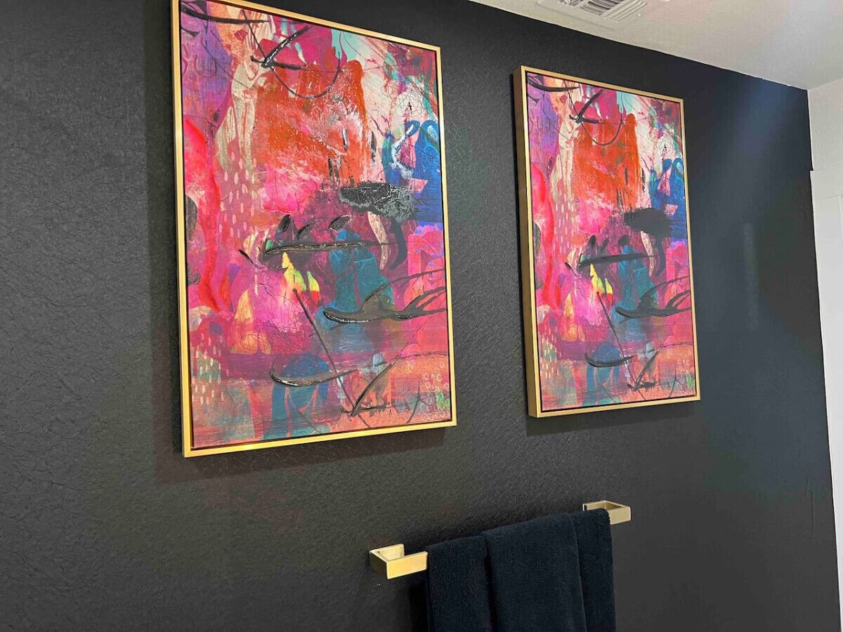 Zwei abstrakte Gemälde an einer dunklen Wand.