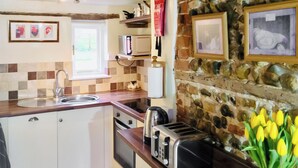 Eine Küche mit Steinwand, Holzarbeitsplatte und einem Toaster.