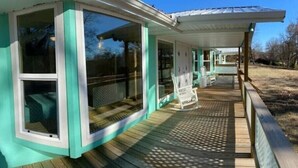A house with a covered porch and large windows. - Cottage 2/Roaring River/TRL/EurekaSprings/Wi-Fi (Eagle Rock)