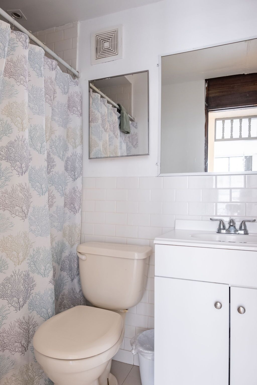 Une salle de bain avec des toilettes, un lavabo et un miroir.