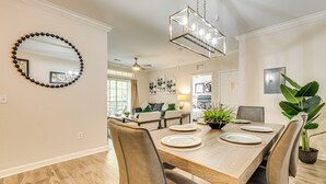A dining area with a wooden table, leather chairs, and a hanging light fixture. - 10 Mi to Disney! Resort Condo at ChampionsGate (Davenport)
