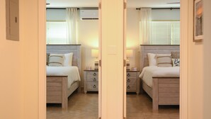Une chambre aux murs recouverts de miroirs, avec deux lits, des tables de chevet et une horloge.