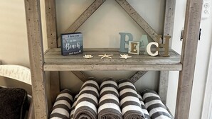 Une étagère en bois ornée d’objets décoratifs et de serviettes enroulées.