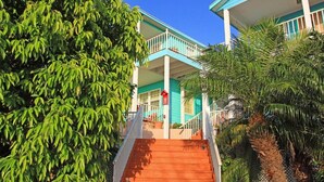 Un immeuble de deux étages avec un escalier menant à un balcon.