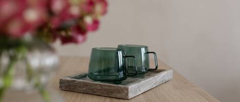 Three glass mugs on a wooden coaster.