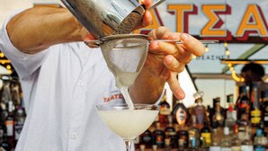 A bartender pouring a drink into a martini glass. - Regal Hotel Mitropoleos (Athens)