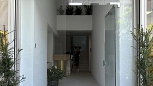 A modern building entrance with a glass facade, a sign reading "REGAL", and potted plants on either side. - Regal Hotel Mitropoleos (Athens)