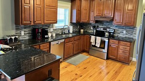A kitchen with wooden cabinets, granite countertops, a stainless steel oven, and a ceiling fan. - 4 BR. Hot Tub. Pet Friendly. May Discounts! (Galena)